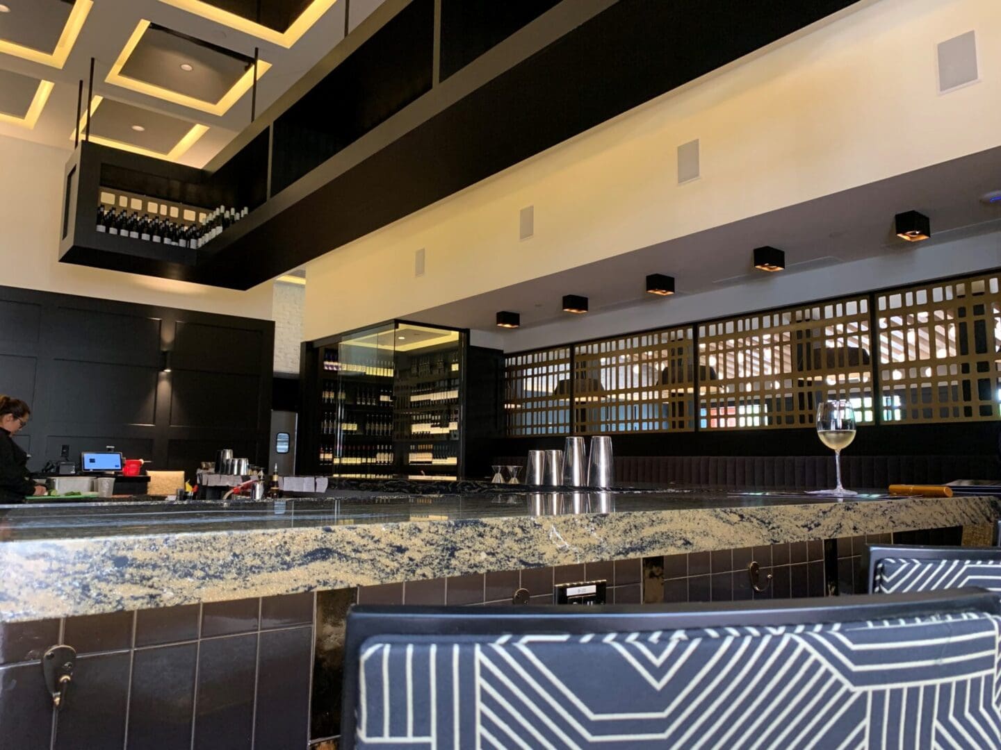 Modern bar with wine wall and seating.