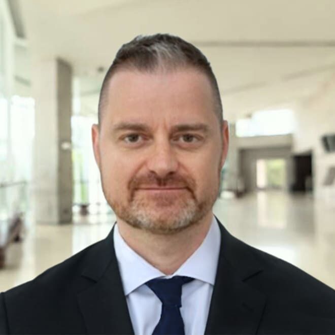 Here's an alt tag for the image: Professional headshot of a man in a suit.